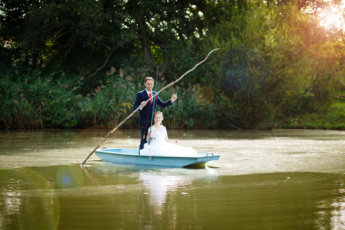 Nevěsta se ženichem sedí v loďce, svatební portrét