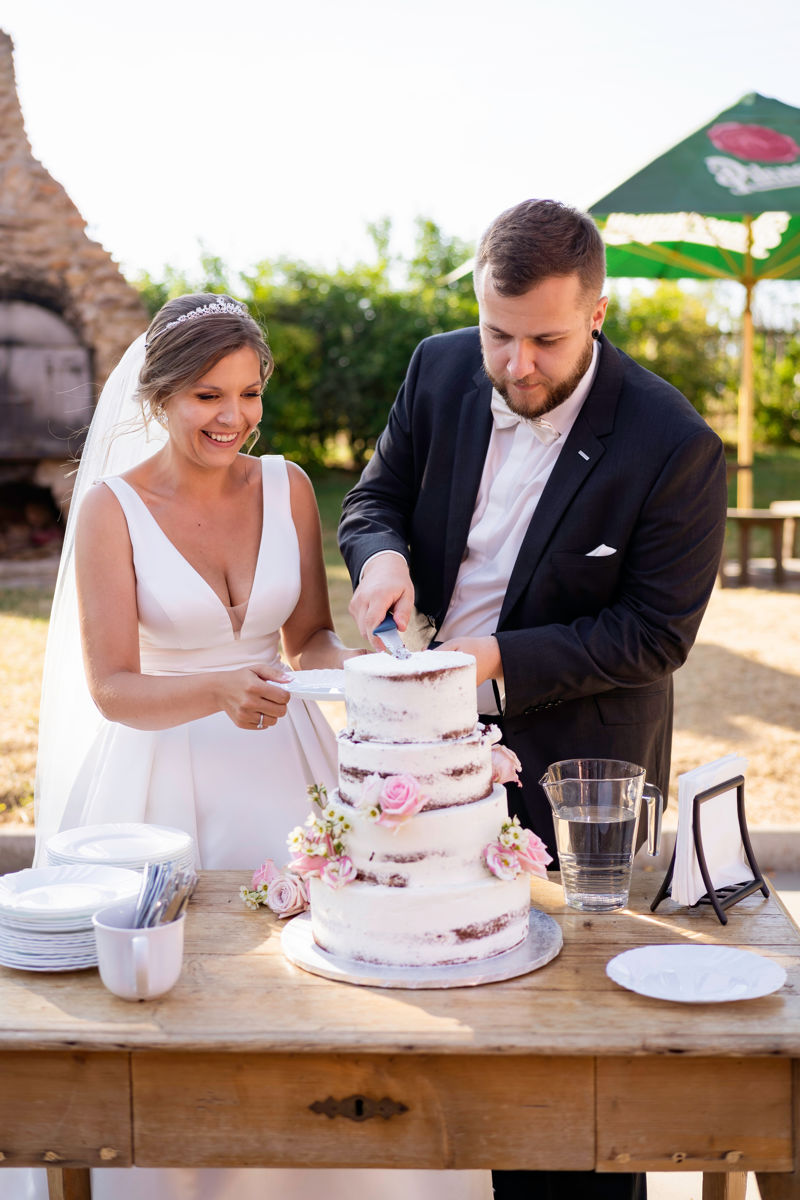 Nevěsta se ženichem krájí dort